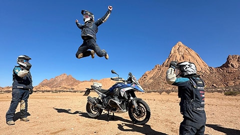 L’équipe italienne lors de son challenge photo. Un pilote saute en l’air depuis sa moto BMW R 1300 GS.